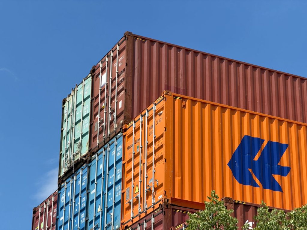 Colorful shipping containers stacked in an outdoor storage area in Germany.